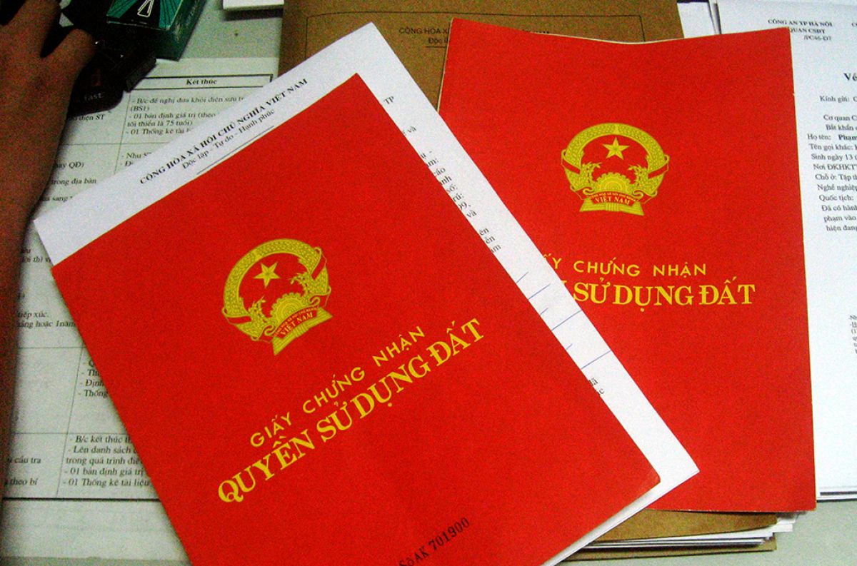 hai quyển sổ màu đỏ đặt trên bàn
