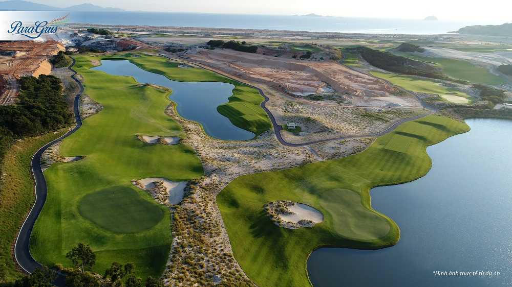 Sân golf xanh rộng lớn với nhiều cây cối phía xa